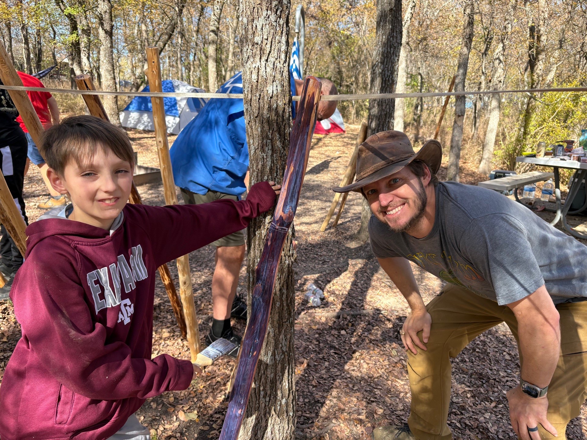 Dad and son painting totem pole